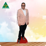 Cardboard cutout of a person in a pink blazer on a red platform with a blurred background