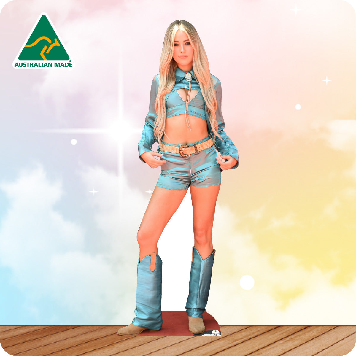 Cardboard cutout of a person wearing a blue outfit with boots on a wooden floor and colorful background.