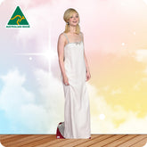 Woman in a white evening gown standing on a wooden floor with a colorful background, Australian Made logo visible.