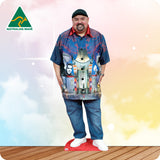 Man wearing a colorful shirt with a graphic design, standing on a wooden floor with a gradient background.