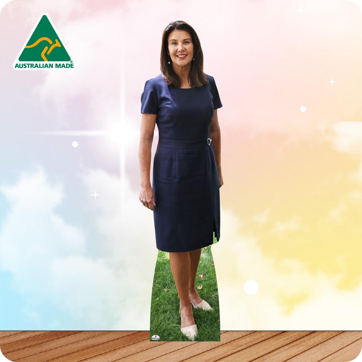Woman in a blue dress standing on grass with a colorful background and Australian Made logo.
