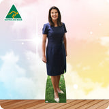 Woman in a blue dress standing on grass with a colorful background and Australian Made logo.