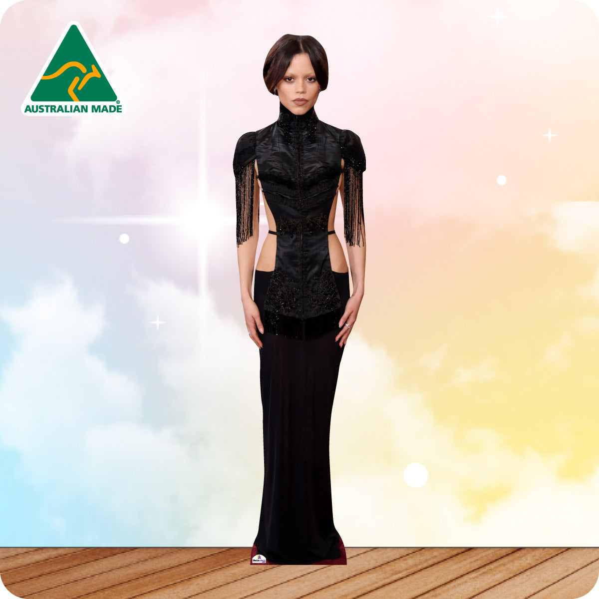 Woman wearing a black evening gown with sheer panels against a colorful gradient background, featuring 'Australian Made' logo.