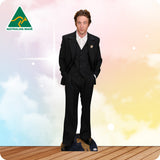 Man in a black suit standing on a wooden floor with a colorful background and Australian Made logo.