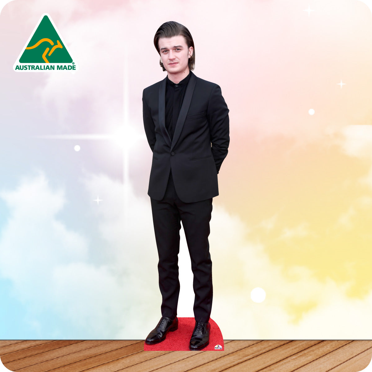 Man in a black suit standing on a red platform with a colorful background and 'Australian Made' logo.