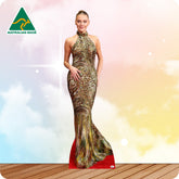 Life-size cardboard standee of a woman wearing an elegant gown on a wooden floor with a colorful gradient background.
