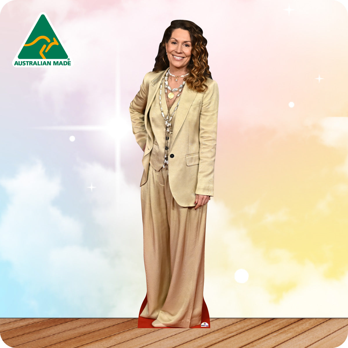 Woman in a beige suit standing on a wooden floor with a colorful background and Australian Made logo.