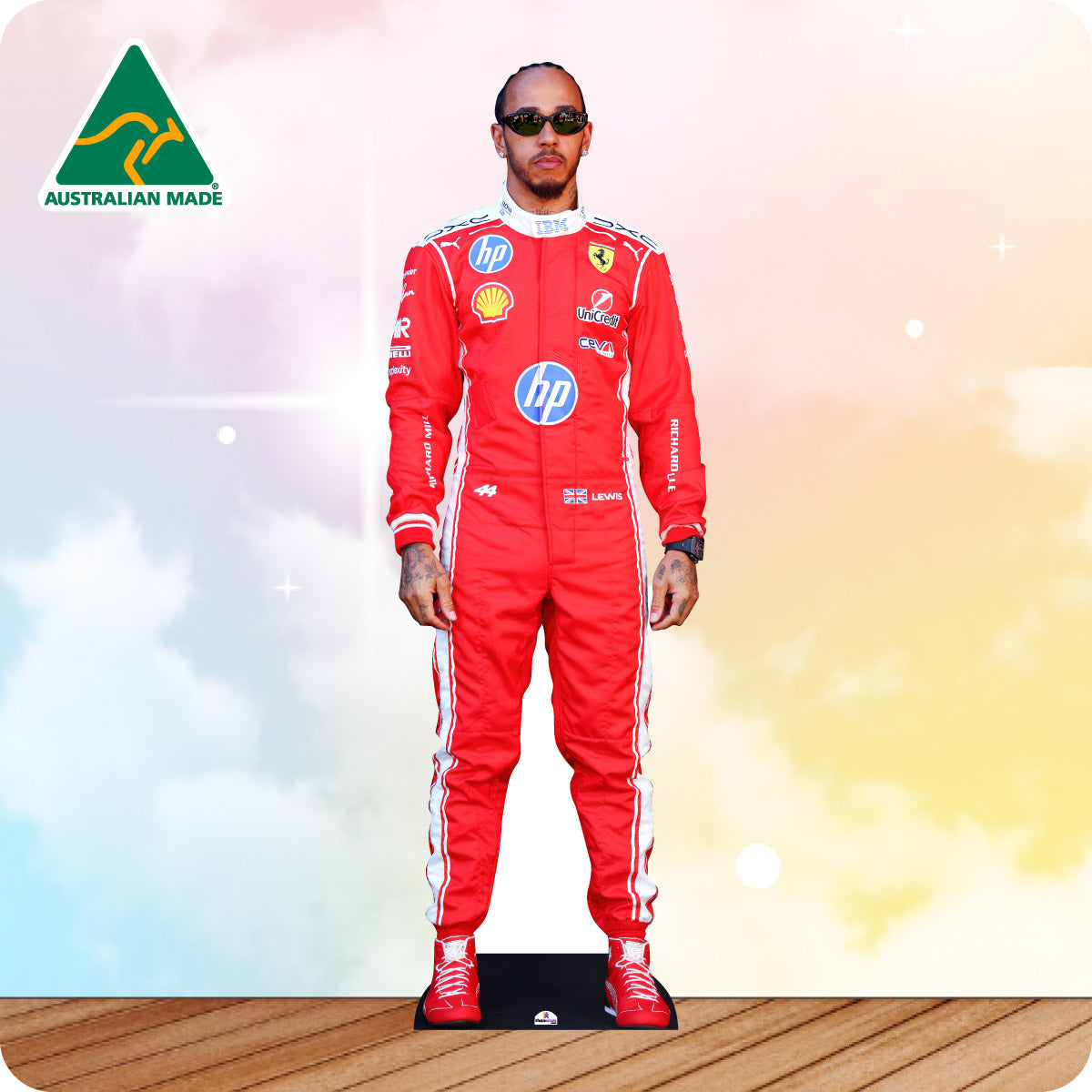 Cardboard cutout of a person in a red racing suit with sponsor logos on a wooden floor.