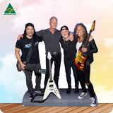 Cardboard cutout of a band with guitars on a wooden floor