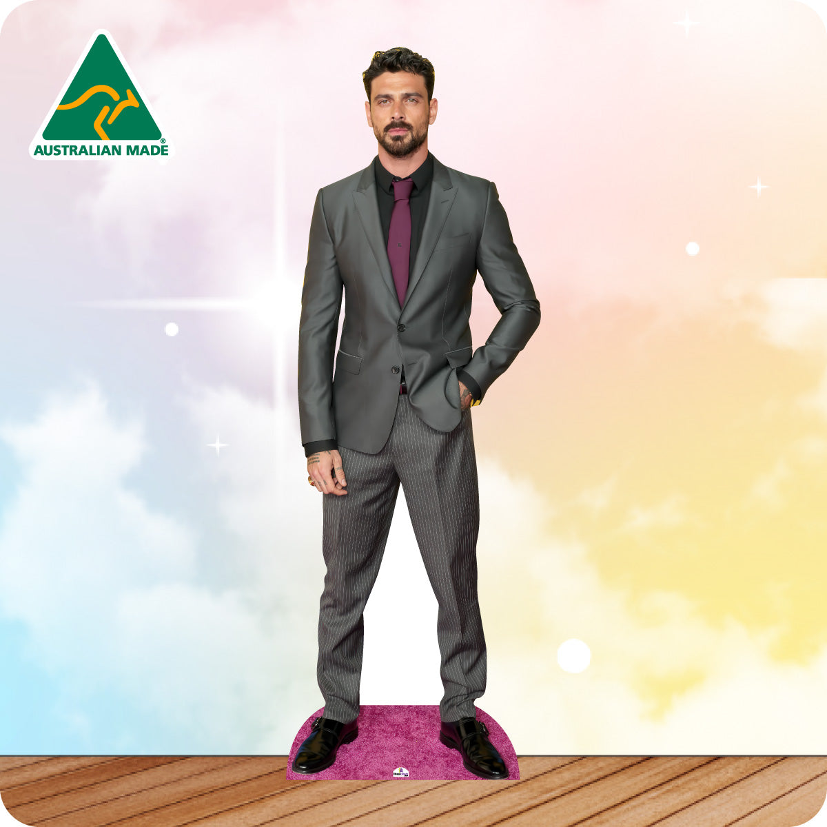 Man wearing a gray suit with a purple tie on a colorful background with 'Australian Made' logo.