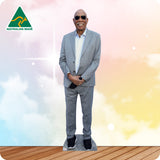 Man in a gray suit standing on a wooden floor with a colorful background and Australian Made logo.