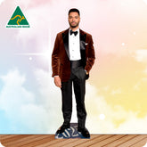 Man in a formal suit standing on a wooden floor with a colorful background and 'Australian Made' logo.