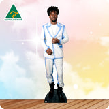 Man in a white suit with blue accents standing on a wooden floor with a colorful gradient background.