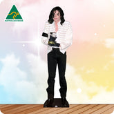 Cardboard cutout of a person in a white jacket and black pants on a wooden floor with a colorful background.