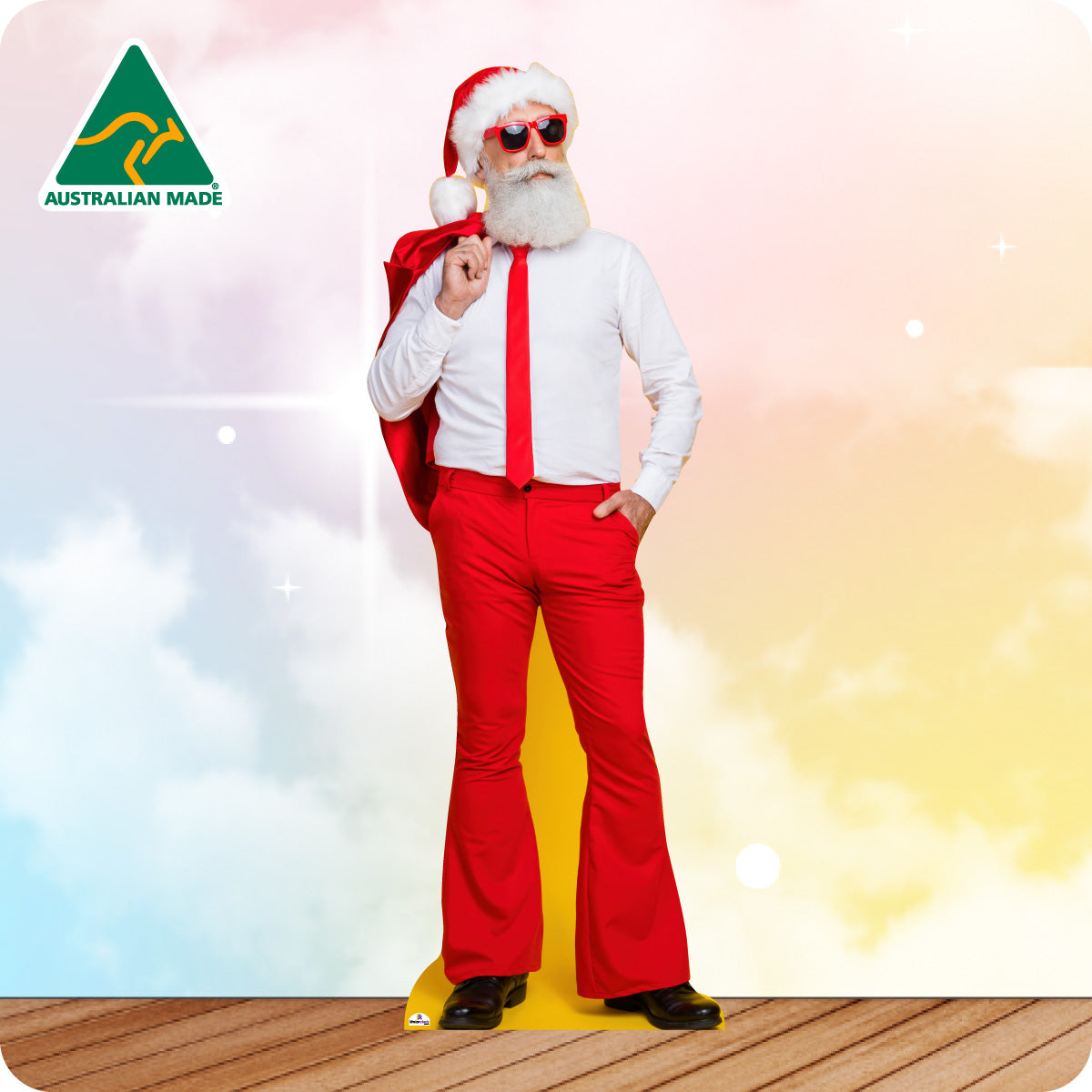 Person wearing a Santa Claus costume with a red bag, sunglasses, and red pants on a colorful background with 'Australian Made' logo.