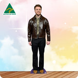 Man wearing a brown leather jacket and black pants on a wooden floor with a colorful gradient background.
