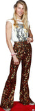 Person wearing a white graphic t-shirt and patterned bell-bottom pants on a plain background