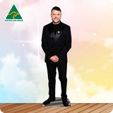 Man in a black suit standing on a wooden floor with a colorful background and 'Australian Made' logo.