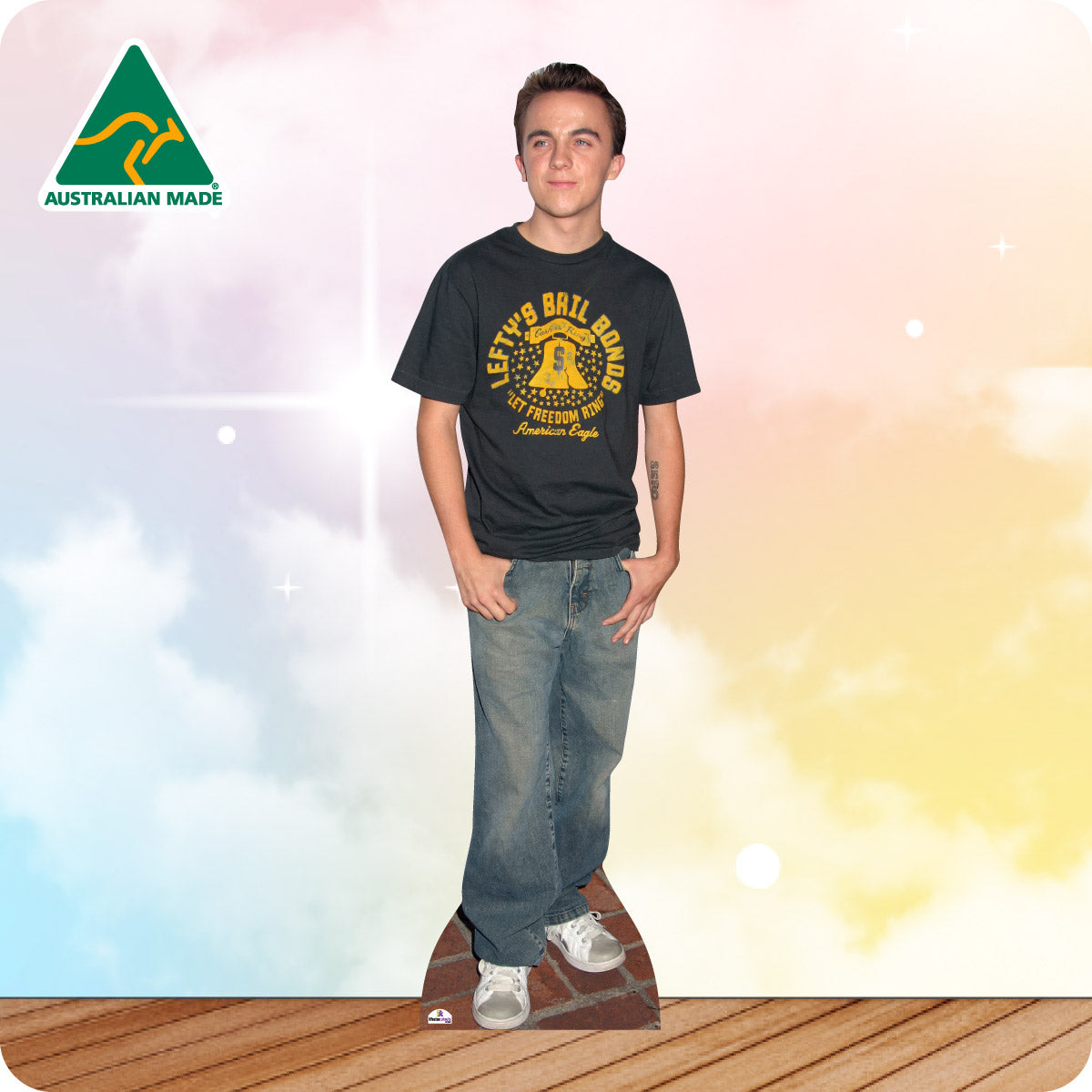 Cardboard cutout of a person wearing a black t-shirt with yellow text and blue jeans, standing on a wooden floor with a colorful gradient background.