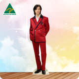Person wearing a red suit with a white shirt, standing on a wooden floor with a colorful gradient background.