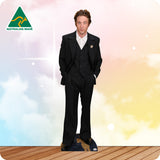 Man in a black suit standing on a wooden floor with a colorful background and Australian Made logo.