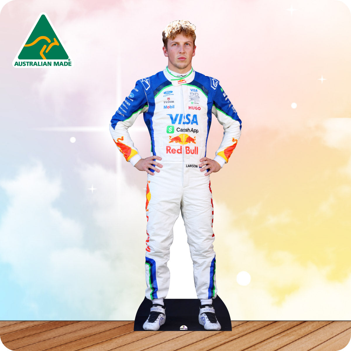 Cardboard cutout of a Formula 1 driver in a colorful racing suit with visible branding on a wooden floor.