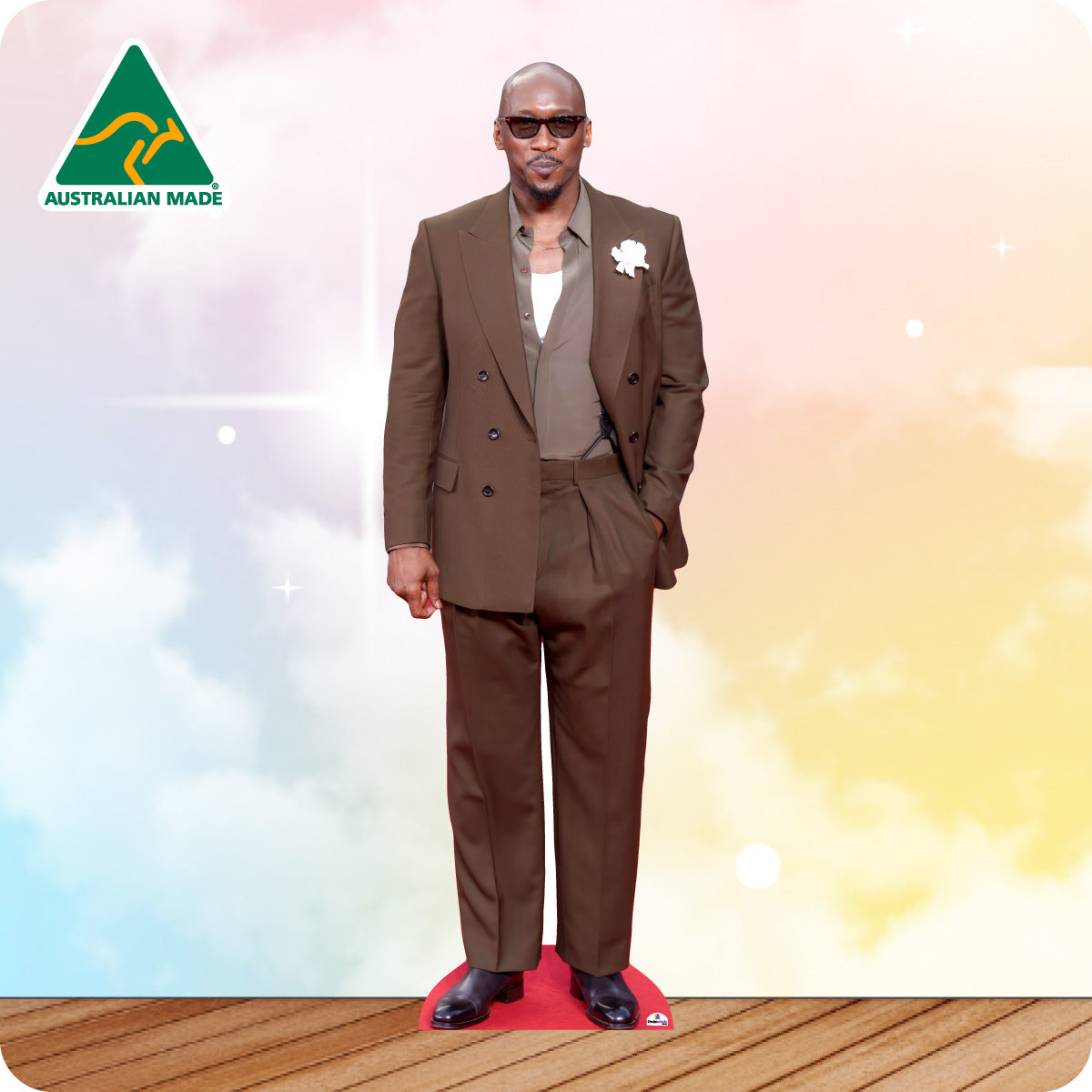 Man in a brown suit standing on a red platform with a colorful background and Australian Made logo.