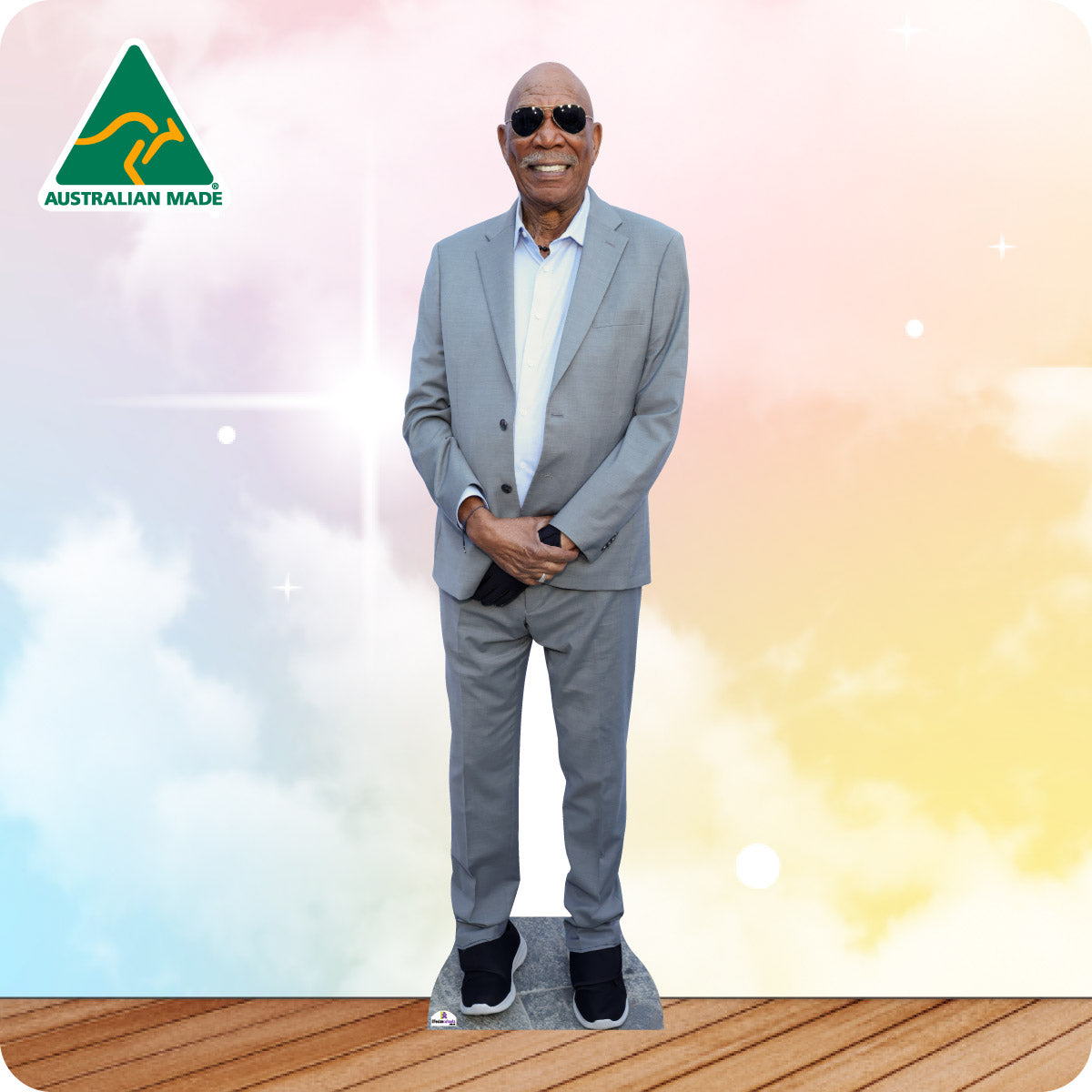 Man in a gray suit standing on a wooden floor with a colorful background and Australian Made logo.