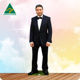 Man in a black suit with bow tie standing on grass with a colorful background and 'Australian Made' logo.