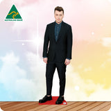 Life-size Sam Smith cutout wearing a black tuxedo, white shirt, black bow tie and dress shoes.