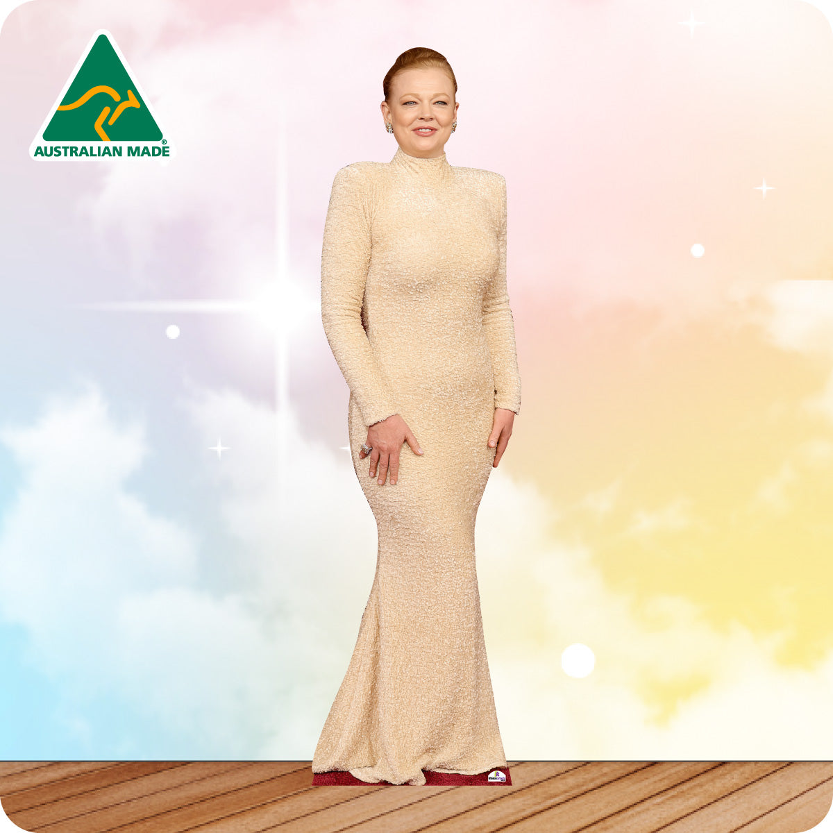 Woman in a beige dress standing on a wooden floor with a colorful background and 'Australian Made' logo.