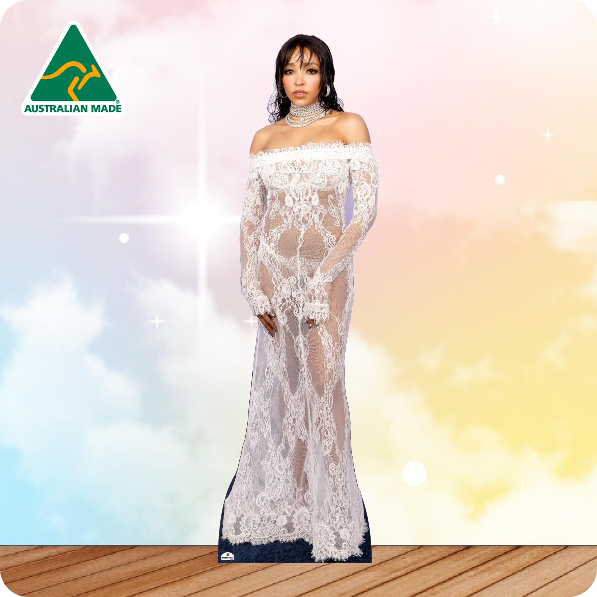 A woman models a floor-length off-the-shoulder lace gown with long sheer sleeves and a fitted silhouette, standing against a pastel sky background with a wooden floor. An Australian Made logo appears in the top-left corner.