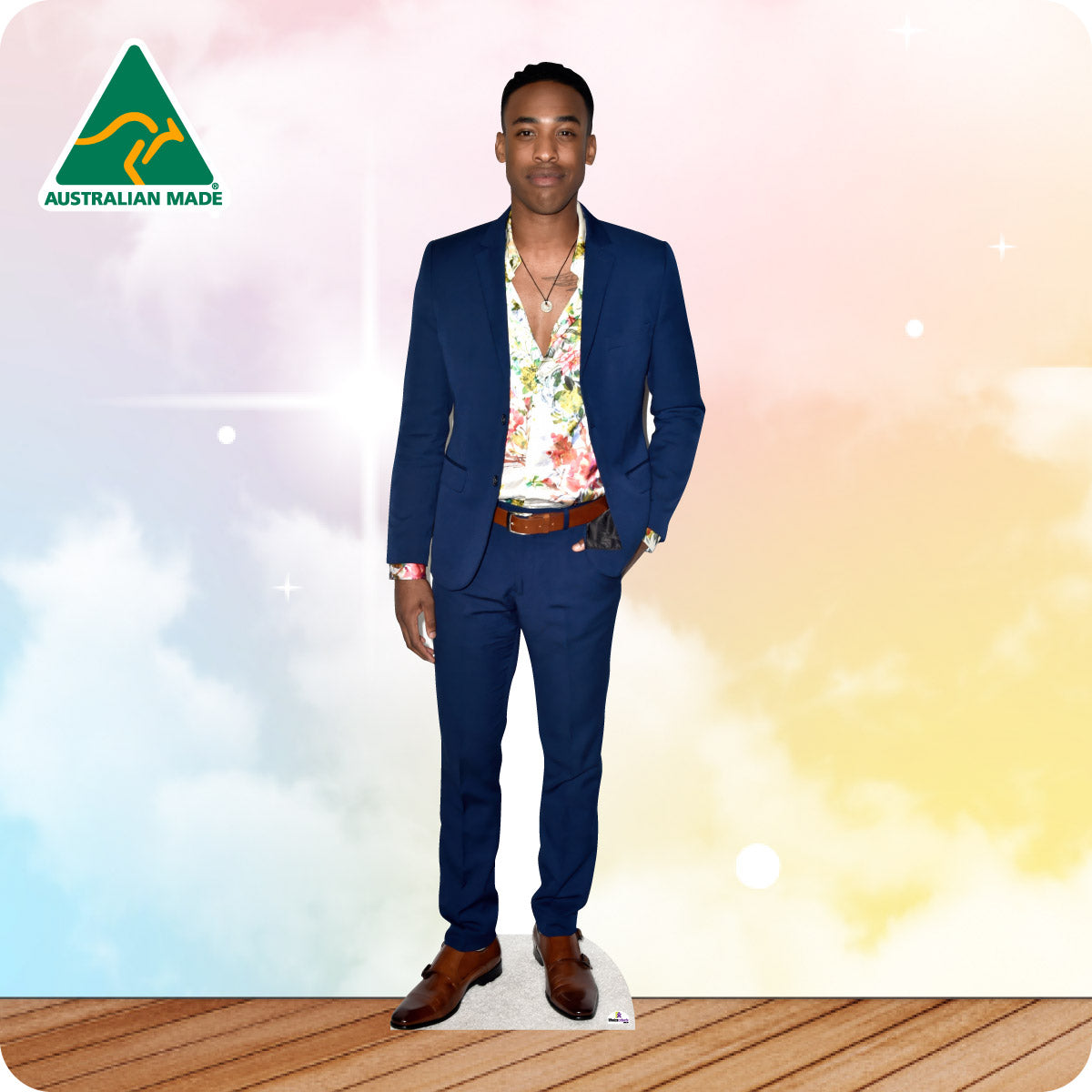 Man in a blue suit with a floral shirt on a white card stand against a colorful background with 'Australian Made' logo.