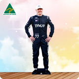 Cardboard cutout of a person in a racing suit with visible branding on a wooden floor.
