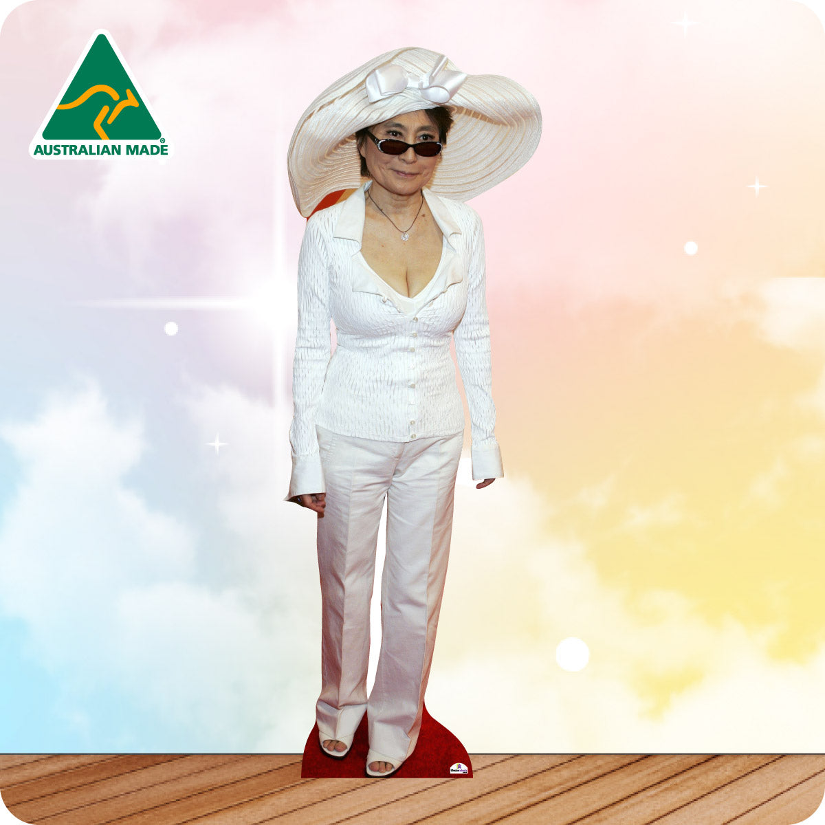Cardboard cutout of a person in a white outfit with a large hat on a wooden floor.
