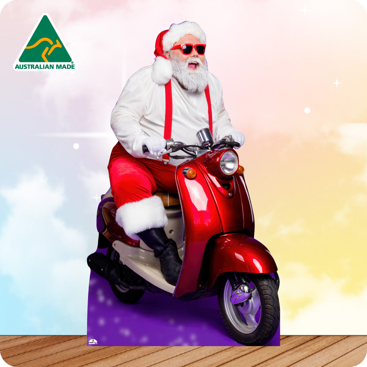 Santa Claus riding a red scooter with an Australian Made logo in the corner.